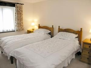 two beds sitting next to each other in a bedroom at Angram Farmhouse in Deepdale