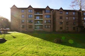 a large building with a grassy yard in front of it at Lux 2 Bedroom Ground Floor Apartment in Edinburgh