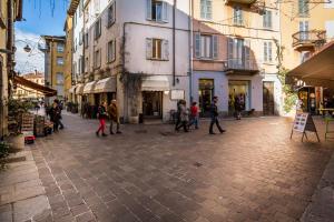 a group of people walking down a street with buildings at Como Unique View - byMyHomeinComo in Como