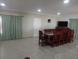 comedor con mesa, sillas y TV en Casa Vacacional "Aguaditas" en La Punta