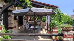 a patio with a table and an umbrella at Artemis Stone House in Psakoudia