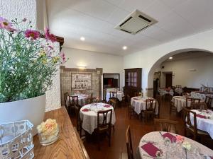 un comedor con mesas, sillas y flores en Hotel La Torretta, en Asís