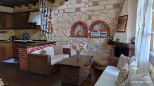 a living room with a brick fireplace and a table at Artemis Stone House in Psakoudia