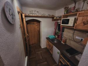 una pequeña cocina con fregadero y un reloj en la pared en Chalupa M&P 2, en Ružomberok