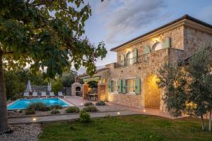 a home with a swimming pool and a house at Villa Perla in Krk