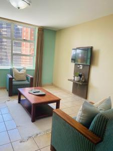 a living room with a couch and a table and a tv at Oceanic 2 Bedroom - Self-catering Apartment in Durban +11 photos