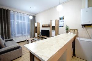 a kitchen and living room with a large white counter top at Apartament Lwowska in Chełm