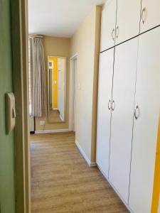 an empty room with white cabinets and a hallway at Oceanic 2 Bedroom Apartment - City View - Self-Catering in Durban
