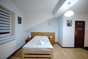 a bedroom with a bed with a teddy bear on it at Apartament Lwowska in Chełm