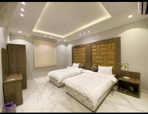 a bedroom with a large bed with white sheets at Royal AlUla Villa in Al-ʿUla +17 photos