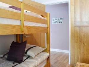 a bunk bed room with two bunk beds and a door at Beudy-oh2 in Dihewid