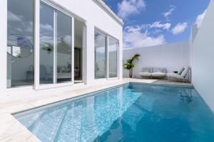 uma piscina numa casa com paredes de vidro em Caya Erasmus 20 em Tanki Lender