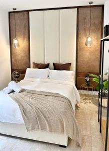um quarto com uma cama grande e lençóis brancos em Tennessee Urban Suites em Málaga