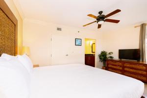 a bedroom with a white bed and a ceiling fan at Divi Village Condo 31 in Palm-Eagle Beach +72 photos