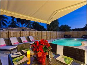 a patio with a table and a swimming pool at Beachway Per ankh (House of Life) in Pompano Beach