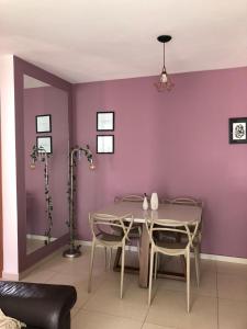 comedor con paredes de color púrpura, mesa y sillas en Apartamento próximo ao Parque e Aeroporto - com academia e piscina en Uberlândia