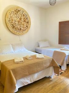 a room with two beds with towels on them at Casa de fadas in Tiradentes