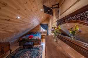 a log cabin bedroom with a bed and vases of flowers at Amazing 14 Berth Villa With Private Pool At Pentney Lakes In Norfolk Ref 34079a in King's Lynn