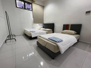 a bedroom with two beds and a window in it at M Guest House2 in Muar