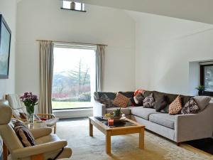 a living room with a couch and a table at Cennen Cottages- Longhouse in Ffair-fâch