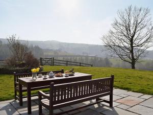 a table and bench with a meal on it at Cennen Cottages- Longhouse in Ffair-fâch