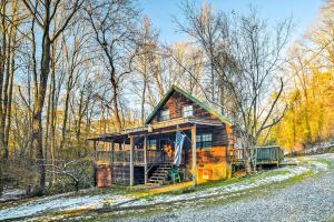 a log cabin in the woods with snow on the ground at Cozy Tellico Plains Cabin with Large Mountain Creek! in Tellico Plains