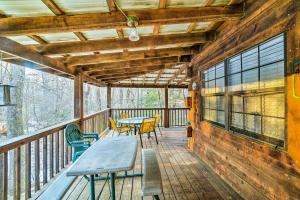 a wooden deck with tables and chairs on it at Cozy Tellico Plains Cabin with Large Mountain Creek! in Tellico Plains