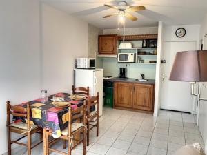 a kitchen with a table and chairs in a room at Studio Balaruc-les-Bains, 1 pièce, 4 personnes - FR-1-503-41 in Balaruc-les-Bains