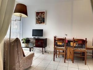 a living room with a couch and a tv at Studio Balaruc-les-Bains, 1 pièce, 4 personnes - FR-1-503-41 in Balaruc-les-Bains