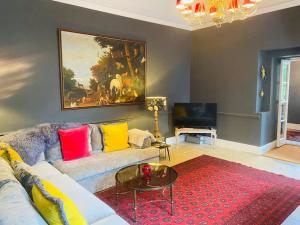 een woonkamer met een bank en kleurrijke kussens bij Stunning Countryside Home with Hot Tub - Sleeps 8 in Thurgarton