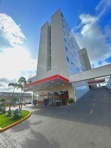 un gran edificio con un estacionamiento delante de él en Hotel Santos Dumont Aeroporto SLZ, en São Luís
