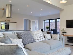 a living room with a couch and a kitchen at The Carriage House in Upper Poppleton