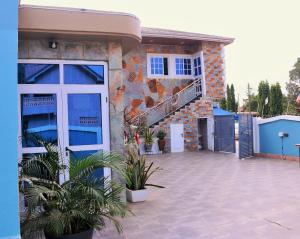 a house with a patio with plants in front of it at Lady M guest House in Tema