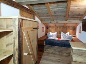 - une chambre avec un lit dans une pièce dotée de murs en bois dans l'établissement Wieserhof Tirol, à Oetz