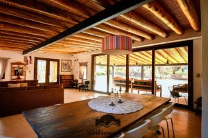 a dining room with a table and a living room at Villa Laureana in Huacalera