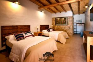 a hotel room with two beds and a television at Villa Laureana in Huacalera