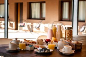 een tafel met ontbijtproducten en flessen sinaasappelsap bij Villa Laureana in Huacalera