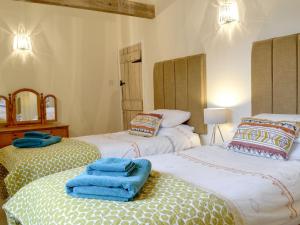 two beds in a room with blue towels on them at The Wood Shed - E1919 in Westleton