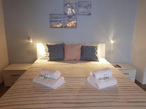 una camera da letto con un grande letto con asciugamani di B&B Antica Fontana a Bernezzo