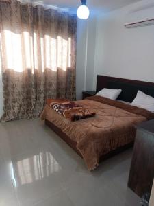 a bedroom with a bed and a window with curtains at Magic view apartment in Wadi Musa