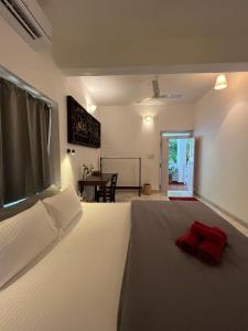 a bedroom with a bed with a red pillow on it at Namaste Jungle - A Boutique Homestay in Assagao