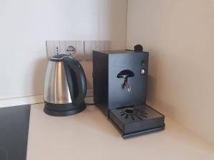 un set per la preparazione del caffè e un bollitore per il tè su un bancone di B&B Antica Fontana a Bernezzo