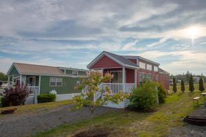 uma casa verde e vermelha numa colina com um quintal em Narrows Too Camping Resort Cottage 11 em Trenton
