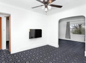 sala de estar con ventilador de techo y TV de pantalla plana en A cozy home with fire place, en Detroit