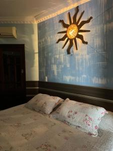 a bedroom with a bed with a painting of a sun on the wall at Casa alto padrão in Cascavel