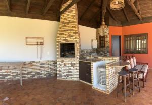 a kitchen with a stove and chairs in a room at Casa alto padrão in Cascavel