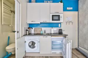 una pequeña cocina con lavadora. en Saint-Malo intramuros - Port à 30M et plage à 200M, en Saint-Malo