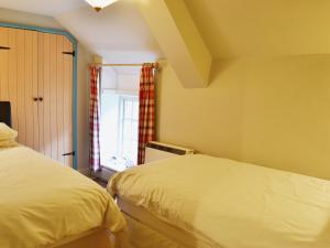 a bedroom with two beds and a window at Georges Cottage - Hsss in Clovelly