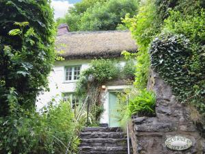 a small house with stairs leading up to it at Georges Cottage - Hsss in Clovelly