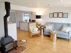 a living room with a stove and a couch at The Old Winery Cottage in Dymock